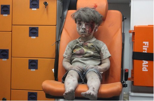Dieses traurige Bild geht um die Welt: Der kleine Omran sitzt nach einen Luftangriff in Aleppo verstört in einem Rettungswagen. Foto: AFP