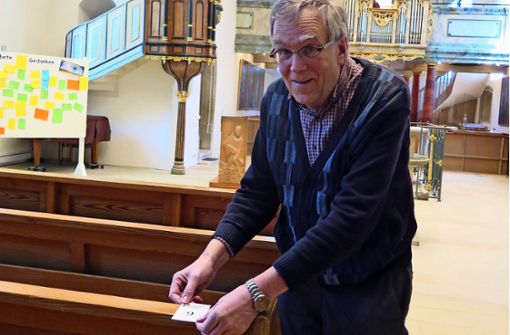 Pfarrer Wolfgang Maier markiert die reduzierten Sitzplätze. Foto: Brigitte Hess