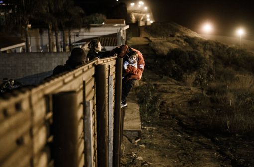 Eine Migrantenfamilie steigt über den Grenzzaun, um von Tijuana, Mexiko, nach San Diego in den Vereinigten Staaten zu kommen (Foto vom 27. Dezember 2018). Foto: AP