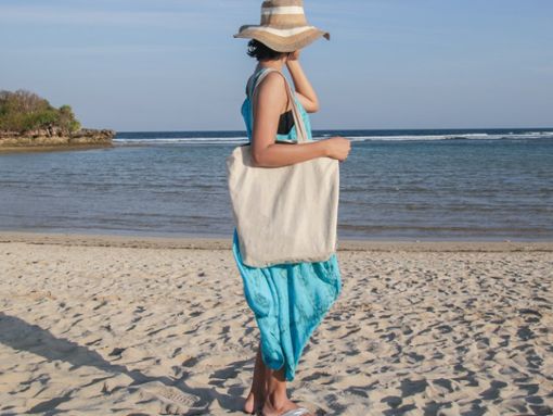 Diese Frau macht es genau richtig: Für den Strand wählte sie ein weites Maxikleid, Schlapphut und Flipflops. Foto: Melimey/Shutterstock.com