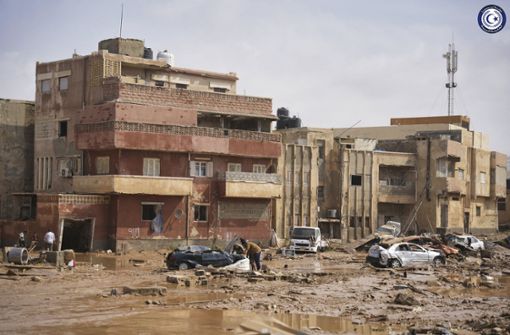 Auf diesem von der libyschen Regierung zur Verfügung gestellten Bild liegen Autos und Trümmer in einer Straße in Derna. Foto: dpa