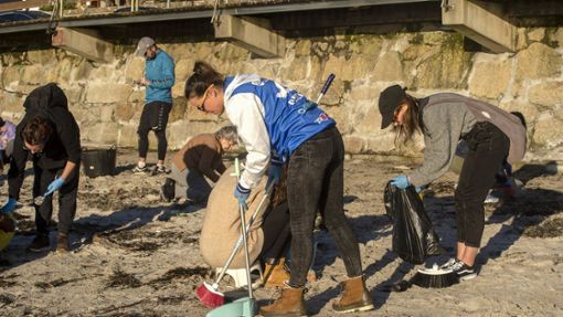 Freiwillige sammeln Plastikpellets am Strand von Panxon. Foto: dpa/Javier Vazquez