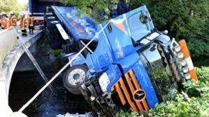 Fahrer bricht mit Lastwagen  durch Geländer und landet im Fluss