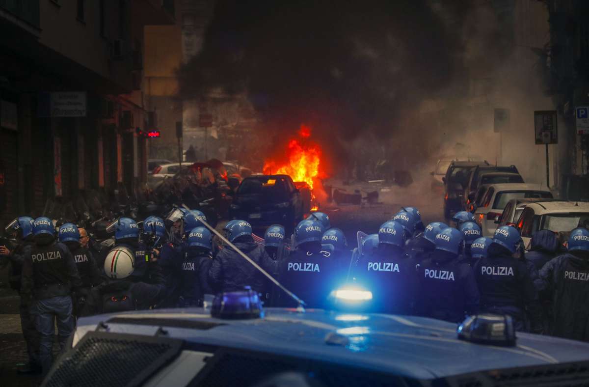 Vermummte Hooligans hatten vor dem Spiel auf einer Straße ein Polizeiauto in Brand gesetzt. Foto: dpa/Salvatore Laporta