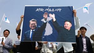 Vorfreude in Seoul: Vor dem Gipfeltreffen halten Südkoreaner ein Plakat mit den Abbildungen der beiden Präsidenten Moon Jae In (links) und Kim Jong Un hoch. Foto: Getty Images AsiaPac
