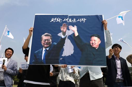 Vorfreude in Seoul: Vor dem Gipfeltreffen halten Südkoreaner ein Plakat mit den Abbildungen der beiden Präsidenten Moon Jae In (links) und Kim Jong Un hoch. Foto: Getty Images AsiaPac