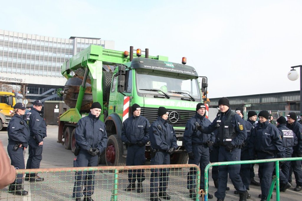 Polizisten bewachen eine Baumaschine. Klicken Sie sich durch weitere Bilder von der Baum-Umpflanzung auf der Nordseite des Stuttgarter Hauptbahnhofs. Foto: Beytekin