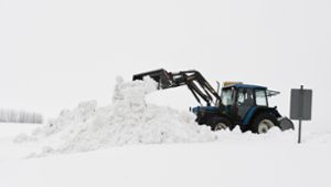 Ein Traktorfahrer in Traunstein, Bayern, räumt Schnee. Foto: dpa