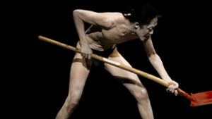 Der Butoh-Tänzer Seiji Tanaka gräbt in „Peenemünde Compassion – Hoffnung“ einen Kleiderhaufen um. Foto: KAN/Uwe Beutnagel-Buchner