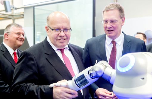 Festo-Chef  Oliver Jung (rechts) mit Wirtschaftsminister Peter Altmaier. Die    Roboterhand  von Festo ist ein  Publikumsmagnet  auf der Messe in Hannover. Foto: dpa