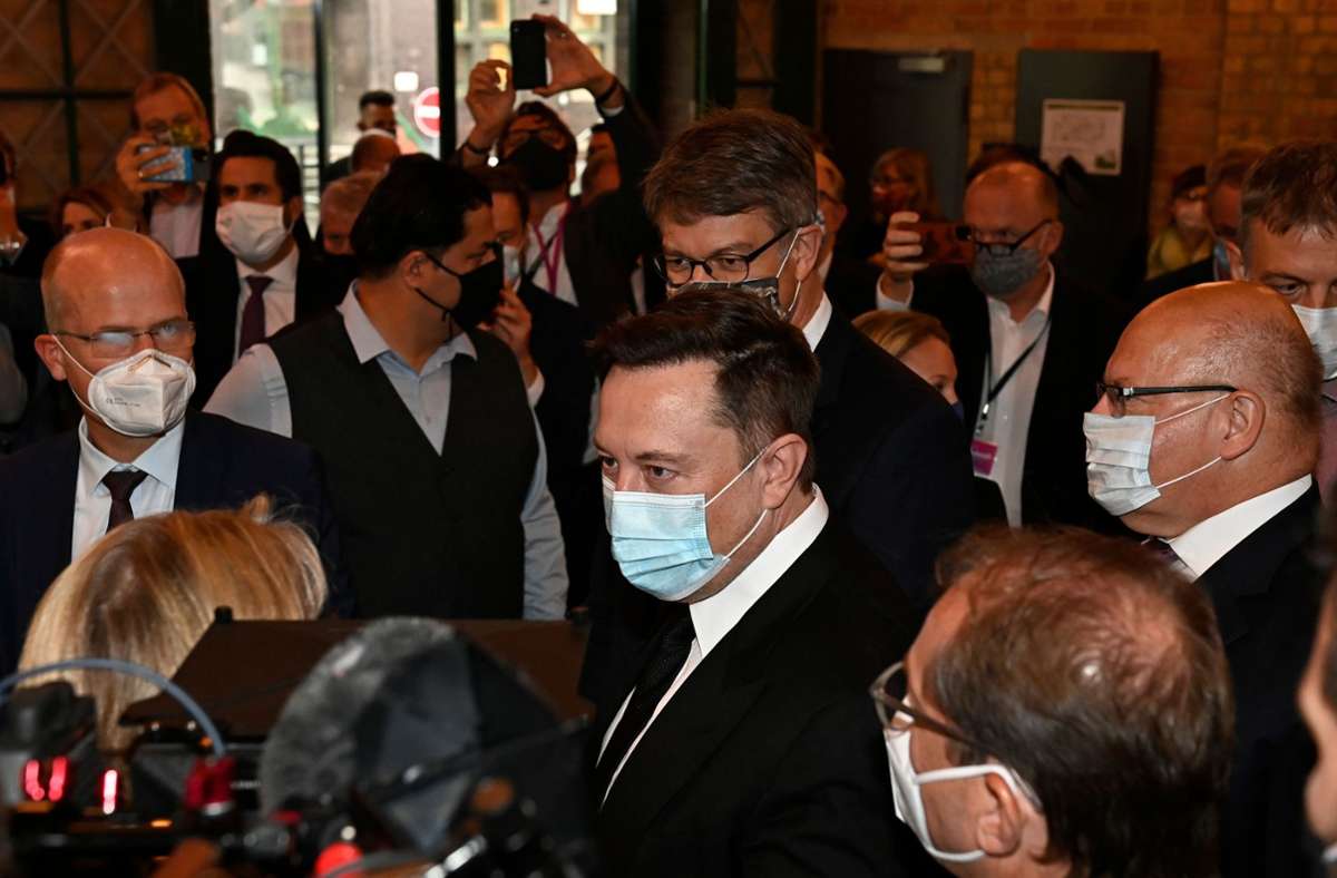 Elon Musk in einer Traube von Politikern bei seinem Deutschlandbesuch. Foto: AFP/TOBIAS SCHWARZ