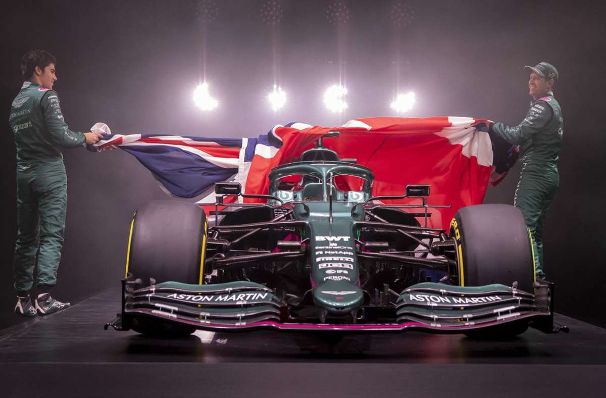 Sebastian Vettel (re.) und Teamkollege Lance Stroll ziehen die riesigen Union Jack vom neuen Formel-1-Boliden Aston Martin AM R21