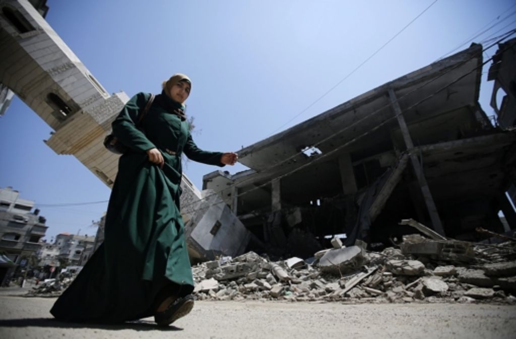 Eine Palästinenserin geht durch die zerstörte Innenstadt von Gaza. Foto: dpa