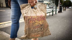Eine Frau trägt eine Plastiktüte, die drei Jahre lang Umwelteinflüssen ausgesetzt war. Foto: Lloyd Russell/University of Plym