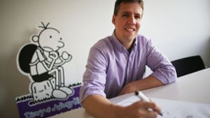 Der US-Kinderbuchautor Jeff Kinney vor einer Abbildung seiner Figur Greg Foto: dpa