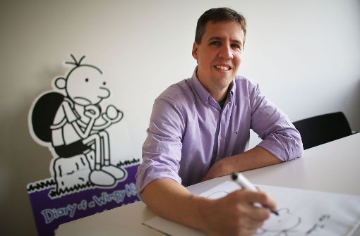 Der US-Kinderbuchautor Jeff Kinney vor einer Abbildung seiner Figur Greg Foto: dpa