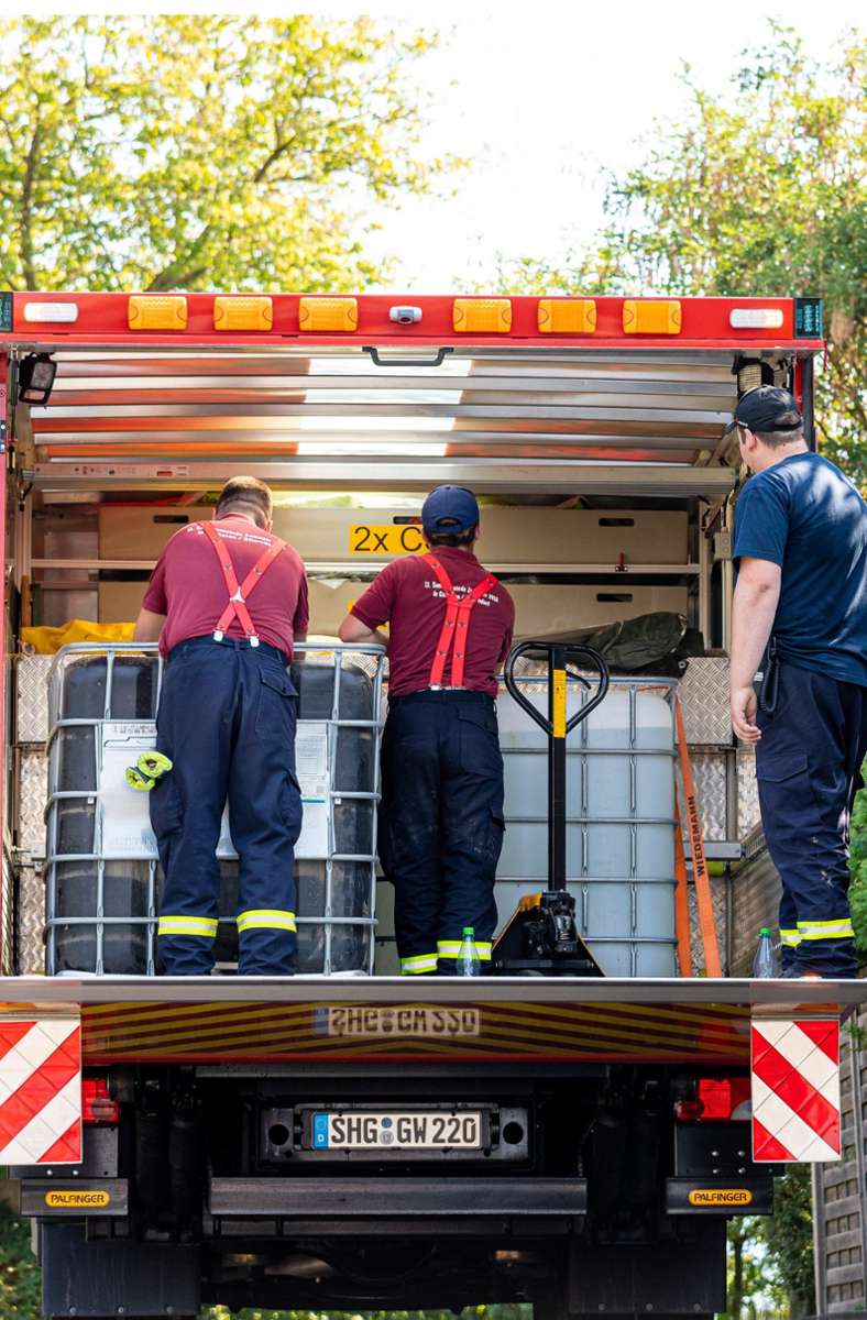 Einsatzkräfte der Freiwilligen Feuerwehr Lauenau entladen Wasserbehälter von einem LKW.