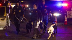 Polizisten suchen mit ihren Hunden nach Hinweisen. Foto: AP