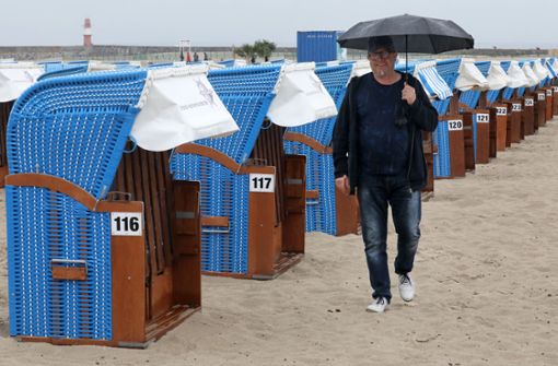 Regenschirm statt Badehose und leere Strandkörbe: So sieht es gerade in Warnemünde aus Foto: dpa/Bernd Wüstneck