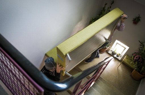 Hassan (links) und Abdul wuchten ein Sofa durchs Treppenhaus – das Möbelstück muss vom vierten Stock zum Transporter Foto: Lichtgut/Max Kovalenko