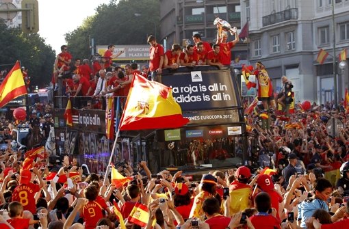 Rot-gelbe Triumphfahrt durch Madrid: Die spanischen Fußball-Helden auf dem Doppeldeckerbus lassen sich von ihren Fans feiern. Ex-VfB-Profi Gerhard Poschner glaubt, dass die WM 2014 auch so enden wird. Foto: dpa