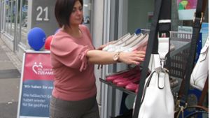 Schuhfachverkäuferin Maria Pirone hat die Kundenstopper vor ihrem Laden aufgestellt. Foto: Eva Schäfer