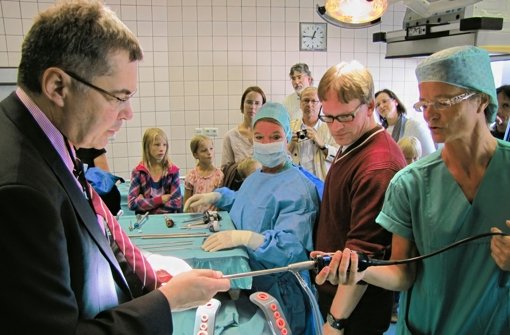 Besucher begutachten die laparaskopische OP-Technik, die der Leitende Arzt der Chirurgie Dr. Bernd Voggenreiter (links) vorführt Foto: Claudia Barner