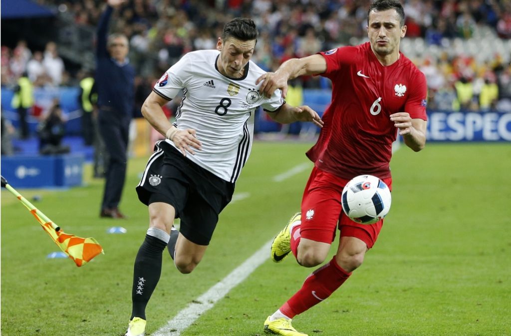 Selten dem Gegner entwischt: Mesut Özil (li.) gegen Polens Tomasz Jodlowiecs