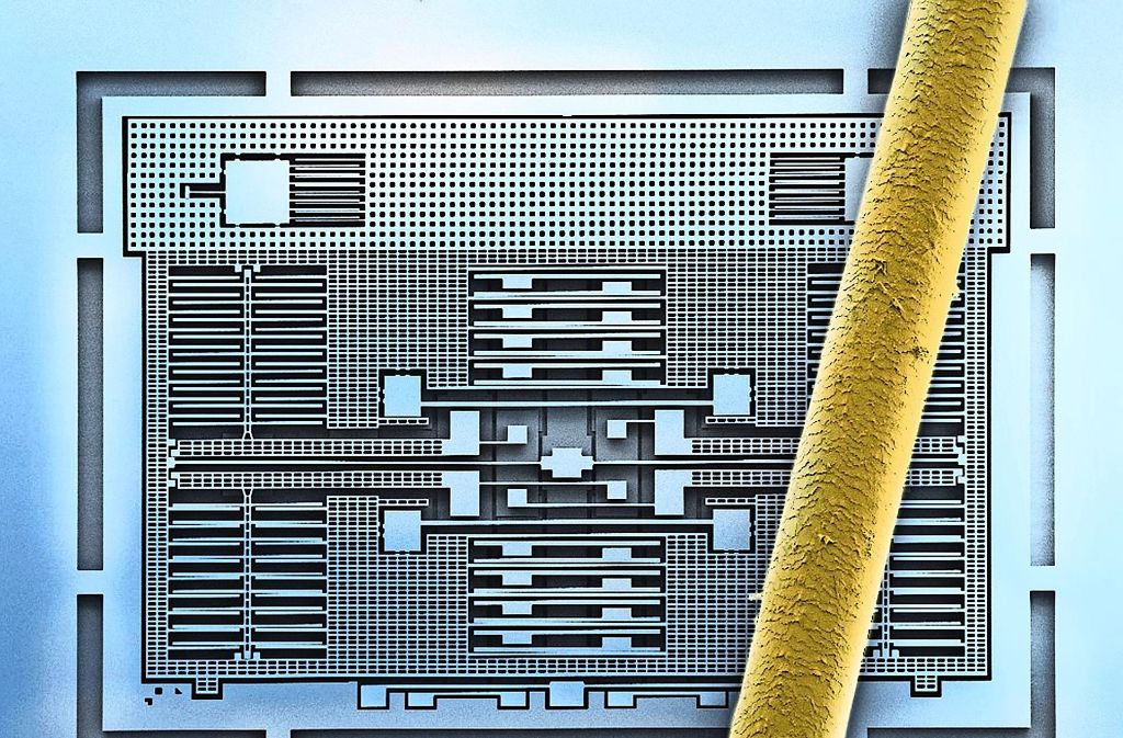 Bausteine für die vernetzte Welt: Das Bild eines Rasterelektronenmikroskops zeigt die fein geätzten Silizium-Strukturen eines Beschleunigungssensors von Bosch. Zum Größenvergleich liegt ein menschliches Haar auf der Struktur. Foto: Bosch