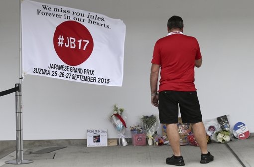 An der Rückseite der Manor-Marussia-Box wurde in Suzuka eine Fahne platziert, Fans legen Erinnerungsstücke an Jules Bianchi ab. Foto: AP