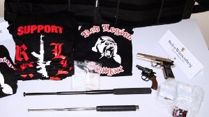 Sichergestellte Waffen und T-Shirts der Rockergruppierung Red Legion nach Wohnungsdurchsuchungen. Foto: Landeskriminalamt