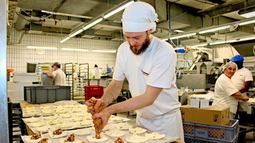 Obwohl viele Arbeitsschritte automatisiert sind, ist Handarbeit  bei der Nellinger Bäckerei Schultheiss unverzichtbar, etwa bei den süßen Stückchen. Foto: /Caroline Holowiecki