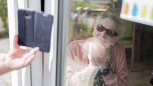 Geburtstagsständchen per Handy durchs schräge Fenster – wer im Heim lebt, ist sehr allein. Foto: dpa