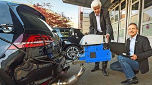Dirk Naber (li.) und Andreas Kufferath arbeiten bei Bosch am sauberen Diesel. Das Bild zeigt eines der Testfahrzeuge mit Abgasmessgerät, das luftdicht mit dem Auspuff verbunden ist. Foto: Ralf Grömminger