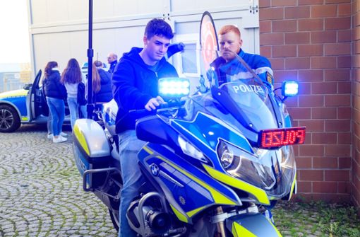 Wow, coole Sache: Dieser junge Mann nimmt mal kurz Platz auf der blauen BMW-Polizeimaschine. Rechts deren Fahrer Daniel Bassermann. Foto: Stefanie Schlecht