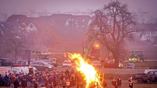 Das Mahnfeuer lockt einige Menschen an. Foto: Simon Granville