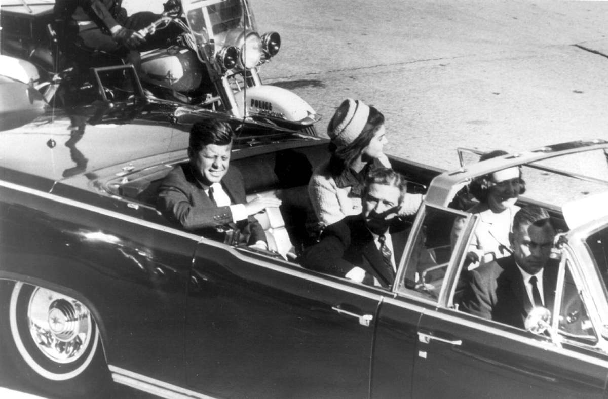 Der damalige US-Präsident John F. Kennedy in der offenen Limousine, in der ihn zwei Schüsse trafen. Einer oder mehrere Täter? Noch sind nicht alle Akten zum Fall freigegeben.