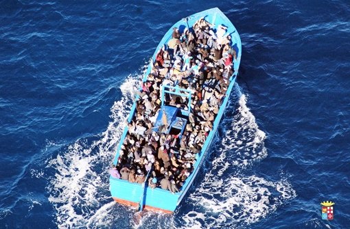 Ein völlig überfülltes Flüchtlingsboot befindet sich auf dem Mittelmeer auf dem Weg nach Italien. Viele Flüchtlinge wollen dort aber nicht bleiben Foto: dpa