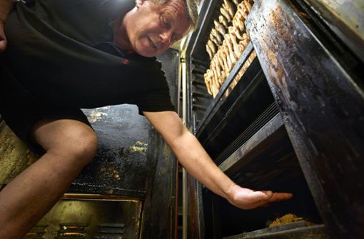 Fischwirt Martin Jeromin prüft die Temperatur im Ofen per Hand. Foto: Gottfried Stoppel