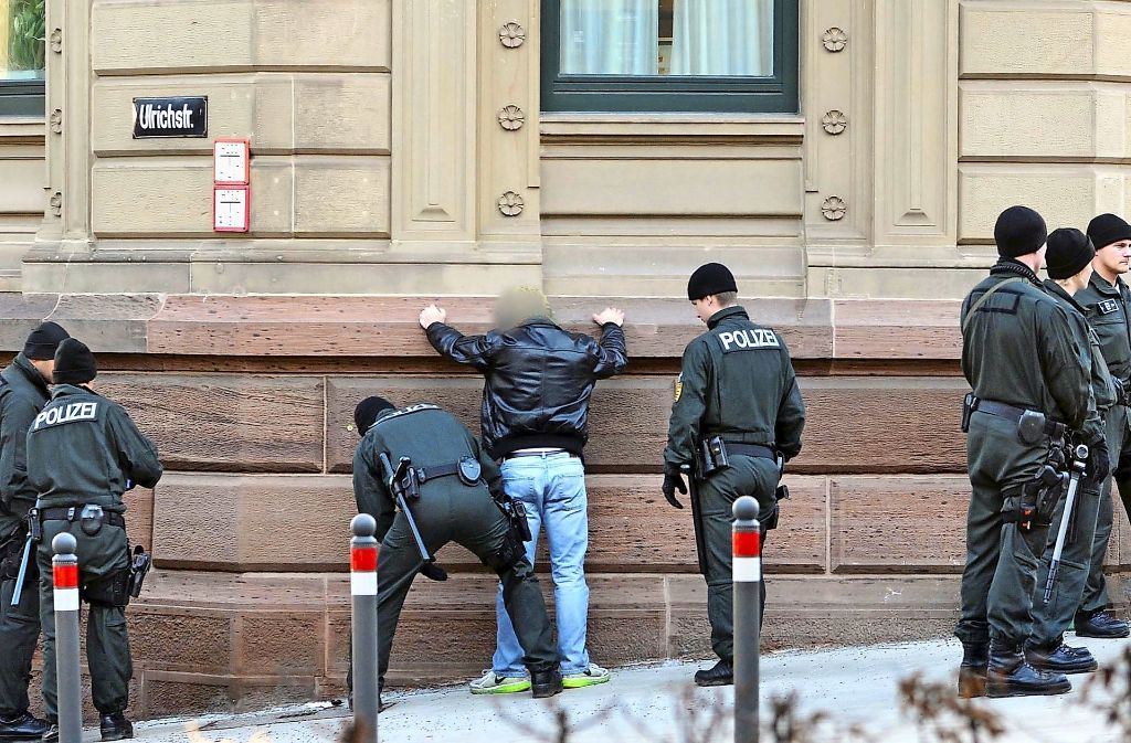 Ein Mann wird im Februar 2015 an einer Straßenecke in der Nähe des Eingangs des Landgerichts Stuttgart von der Polizei kontrolliert. Mehr als zwei Jahre nach einem tödlichen Streit unter Rockergruppen in Esslingen sind weitere Beteiligte verurteilt worden.