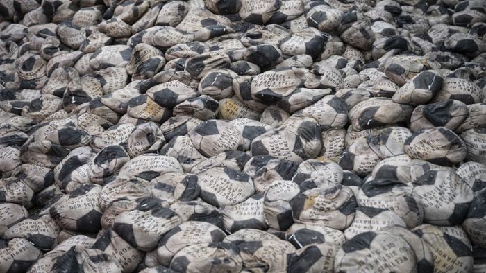 Mit Sand gefüllte Fußbälle sollen auf Missstände in  Katar hinweisen