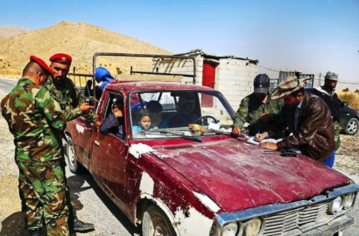 Syrische Soldaten kontrollieren einen Wagen mit heimkehrenden Flüchtlingen. Foto: dpa