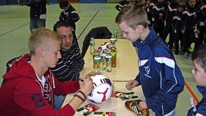 VfB-Profi Timo Baumgartl (links) gibt den Kindern des  TSV Schmiden Autogramme – auch auf Fußbälle und Schuhe. Foto: Robin Laure