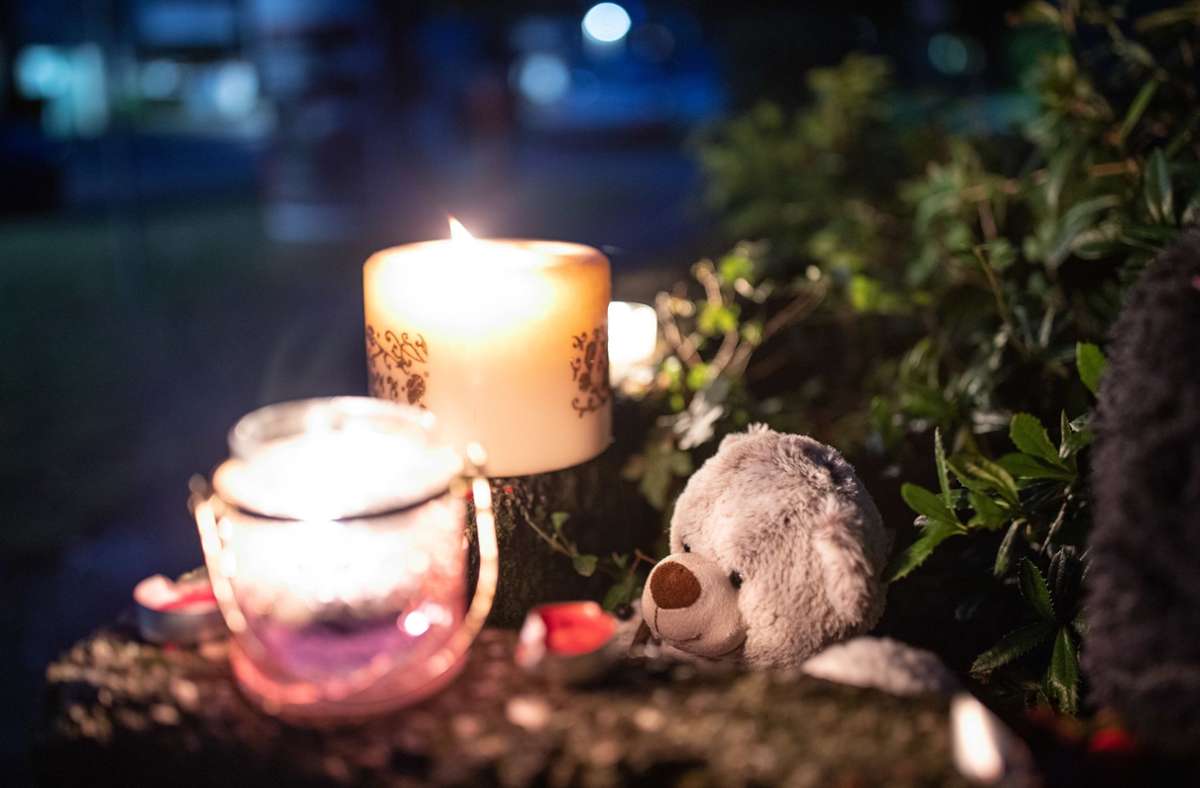 Ein Teddybär und Kerzen liegen und stehen vor dem Haus. Am Freitag wollen die Ermittler Nachbarn befragen und bei einer Pressekonferenz über die Hintergründe des Falls informieren.