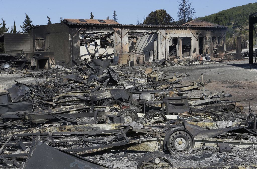 Überreste mehrerer Fahrzeuge und die Ruine eines abgebrannten Supermarktes in La Londe-les-Maures.