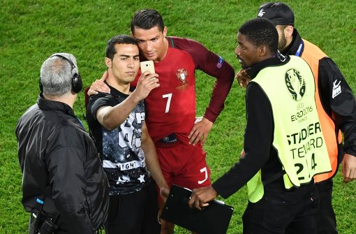 Ein Selfie mit dem Star: dieser Fan ist nach dem Spiel gegen Österreich auf den Platz gestürmt, um ein Foto mit Ronaldo zu machen. Foto: AFP